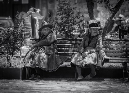 Indigenous older women wearing traditional Andean clothing, sitting on a bench, Cusco, Peru, 2017 Women in traditional outfit sitting on a bench in Downtown Cusco.